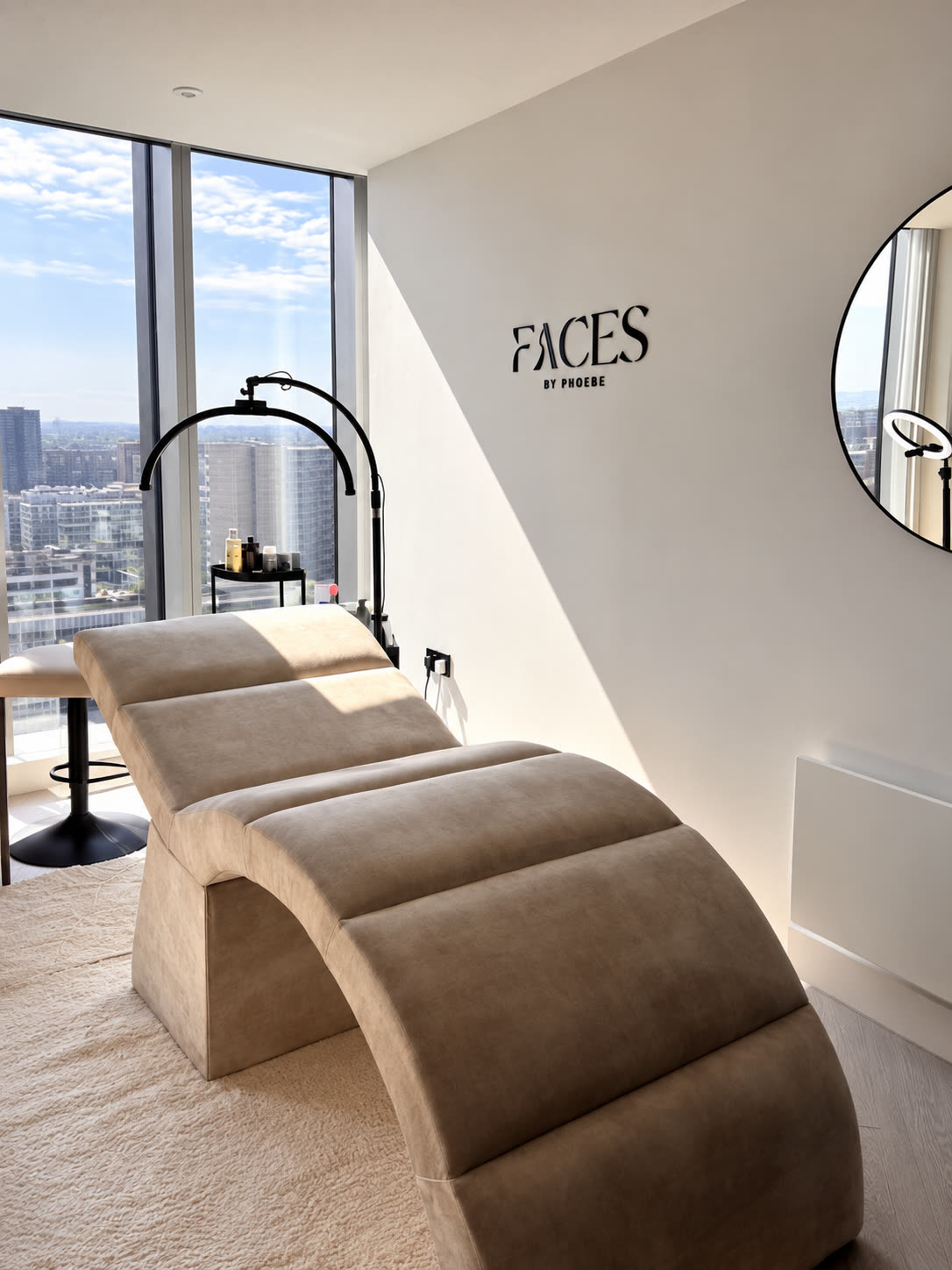 The Faces By Phoebe studio: a curved treatment bed by floor-to-ceiling windows over Manchester